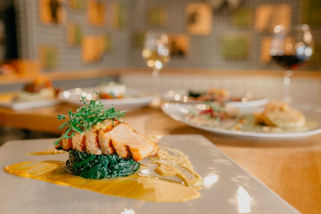 pexels-photo-7627415 Tasty appetizing salmon fillet and green spinach decorated with arugula on plate with sauce on table in restaurant